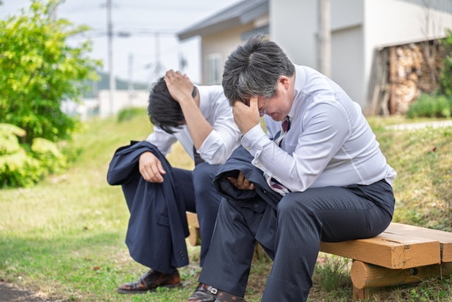 がっくり肩を落とす男性二人