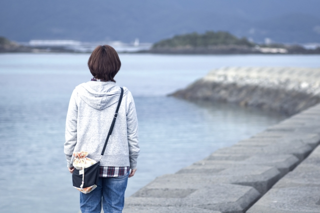 海を眺める女性の後ろ姿